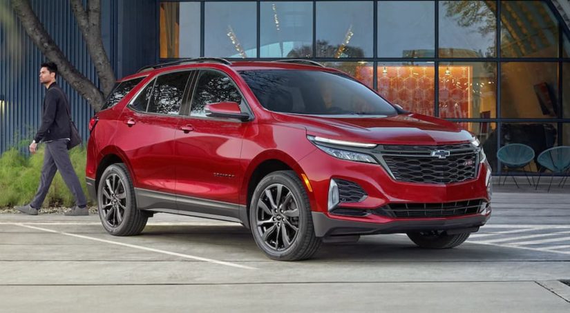 A red 2022 Chevy Equinox is shown parked in front of a modern building.