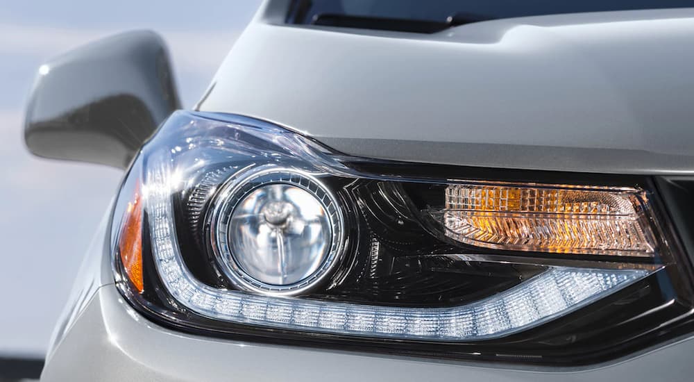 The passenger side headlight of a white 2022 Chevy Trax is shown in close up.