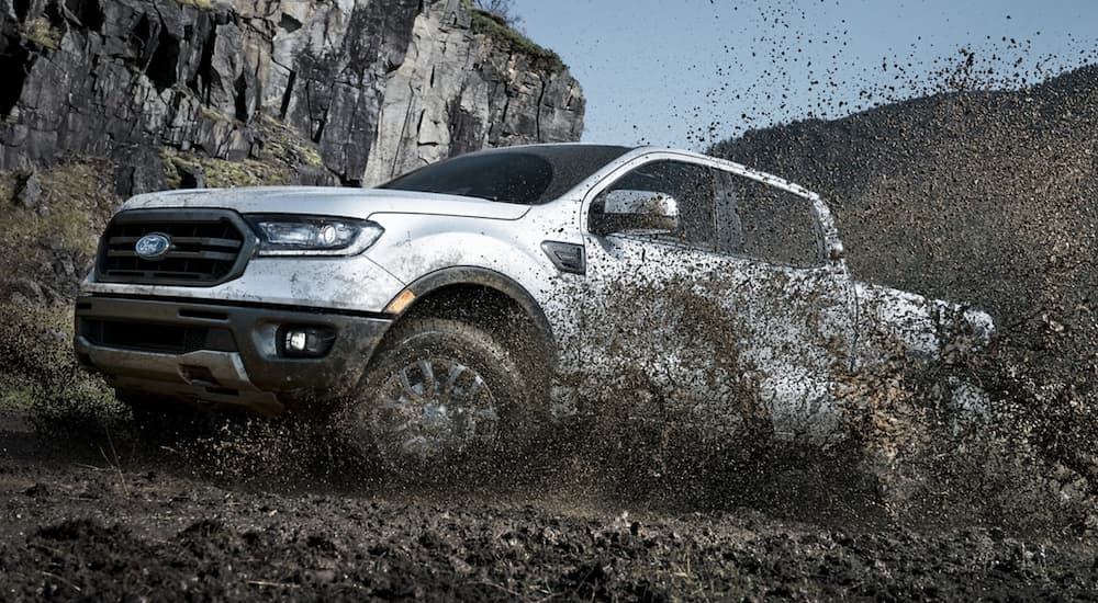 A white 2021 Ford Ranger is shown off-roading through the mountains.