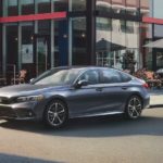 A grey 2022 Honda Civic Touring Sedan is shown parked in front of a coffee shop.
