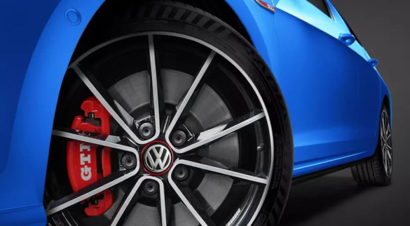 A blue 2022 Volkswagen Golf GTI is shown from a low angle.