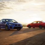 A blue 2021 Subaru STI is shown facing a red 2021 WRX.