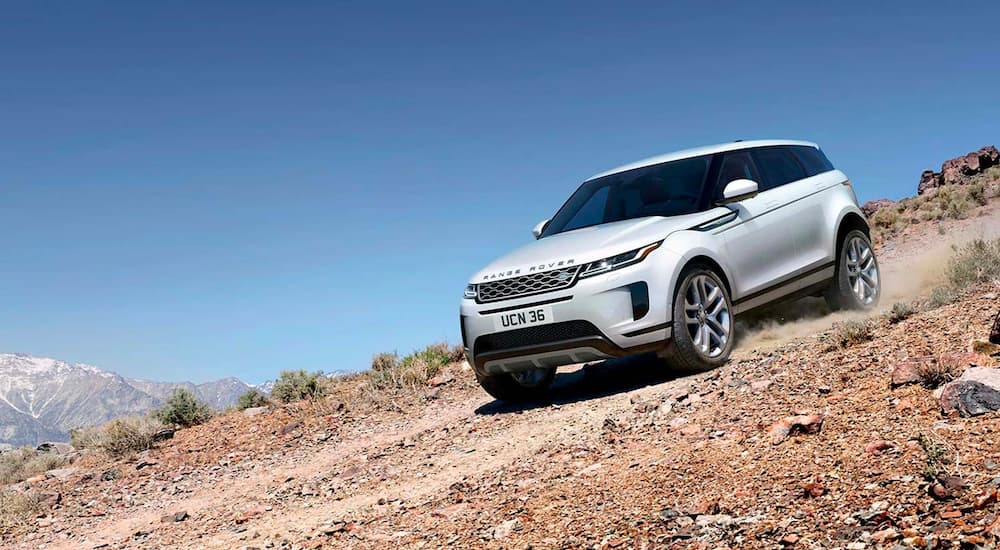 A white 2022 Range Rover Evoque is shown driving down a rocky path.