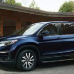 A blue 2021 Honda Pilot EX-L is shown parked in front of a modern house.