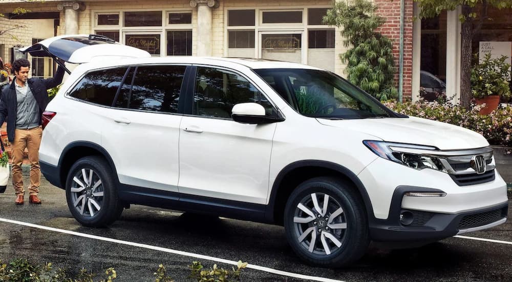 A white 2021 Honda Pilot EX-L is shown parked in front of a store after leaving a Honda Pilot dealer.