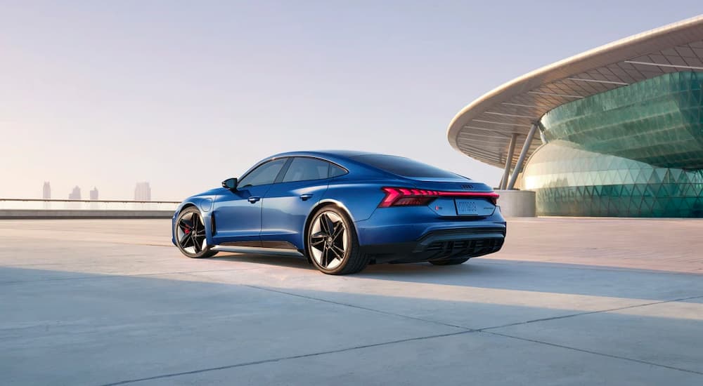 A blue 2022 Audi e-tron GT is shown parked outside a modern building.
