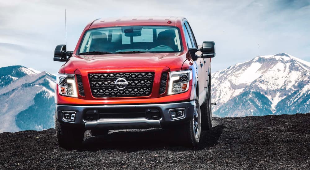A red 2018 Nissan Titan is shown driving in the mountains.