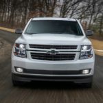 A white 2019 Chevy Tahoe RST is shown from the front driving on an empty road.