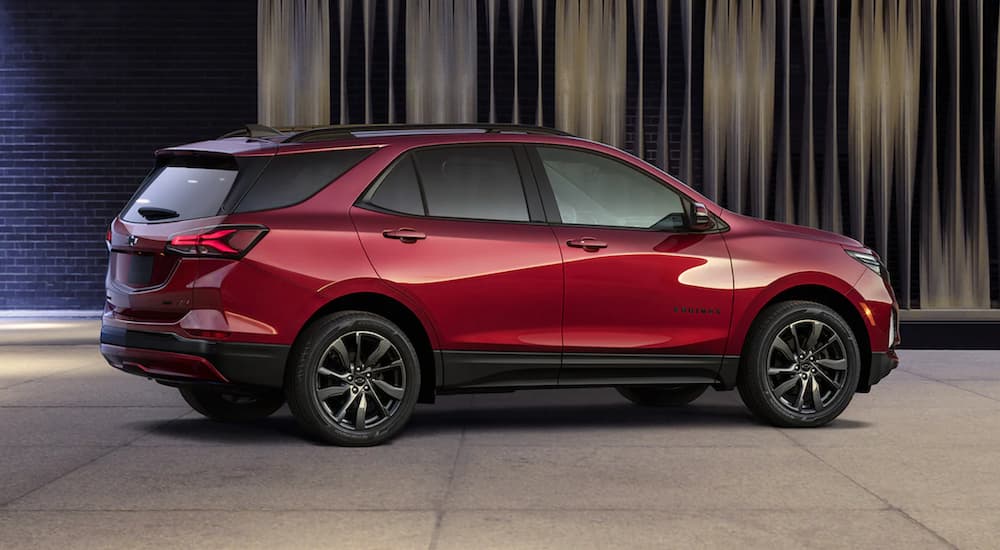 A red 2022 Chevy Equinox is shown parked in a modern gallery after looking at new Chevy vehicles in stock.