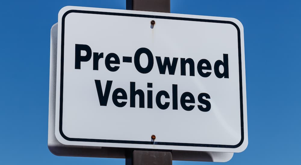 A white sign says pre-owned vehicles.