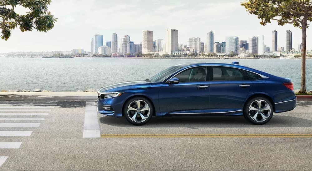 A blue 2020 Honda Accord Sport is shown from the side stopped at a stoplight.