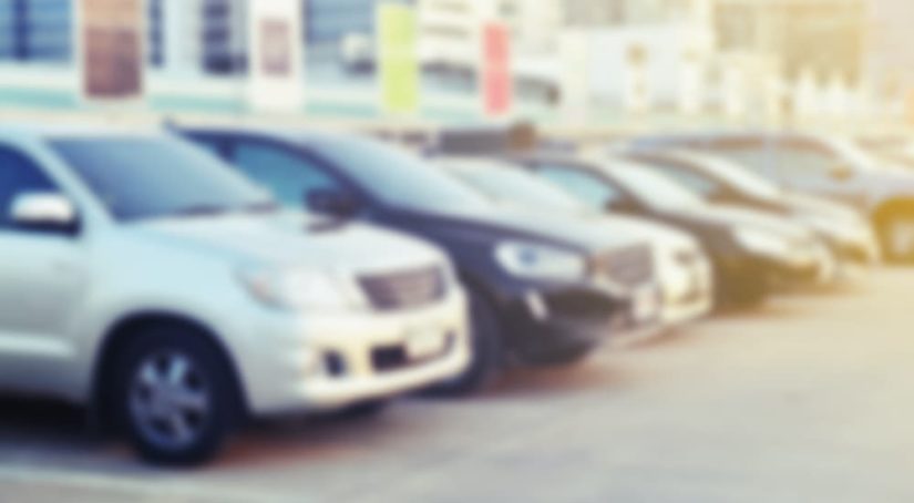 A row of cars is shown at a used car dealer.