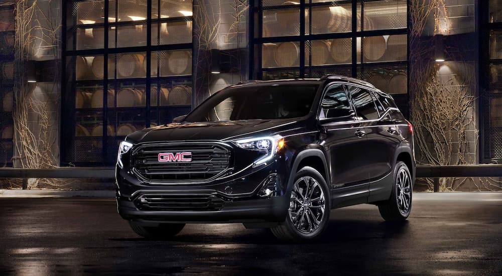 A black 2021 GMC Terrain Elevation is shown parked outside of a building at night.