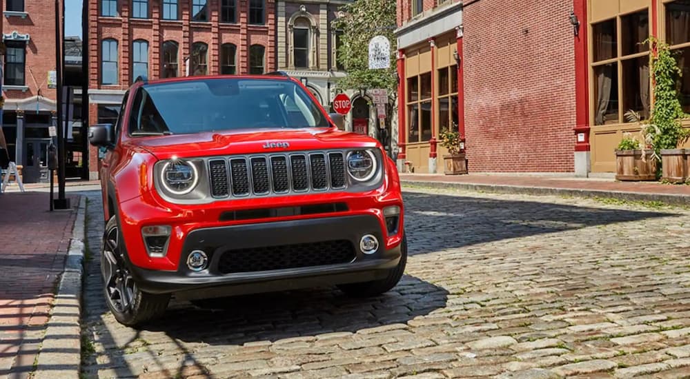 A red 2021 Jeep Renegade is shown from the front parked in a city.
