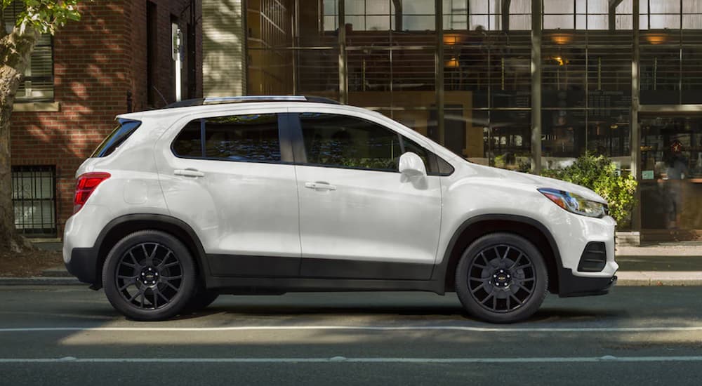 A white 2021 Chevy Trax is shown from the side parked in a city during a 2021 Jeep Renegade vs 2021 Chevy Trax comparison.