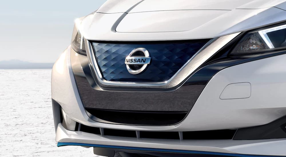 A white 2021 Nissan LEAF shows the grille in close up.