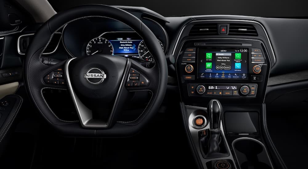 The black interior and infotainment screen of a 2021 Nissan Maxima is shown.