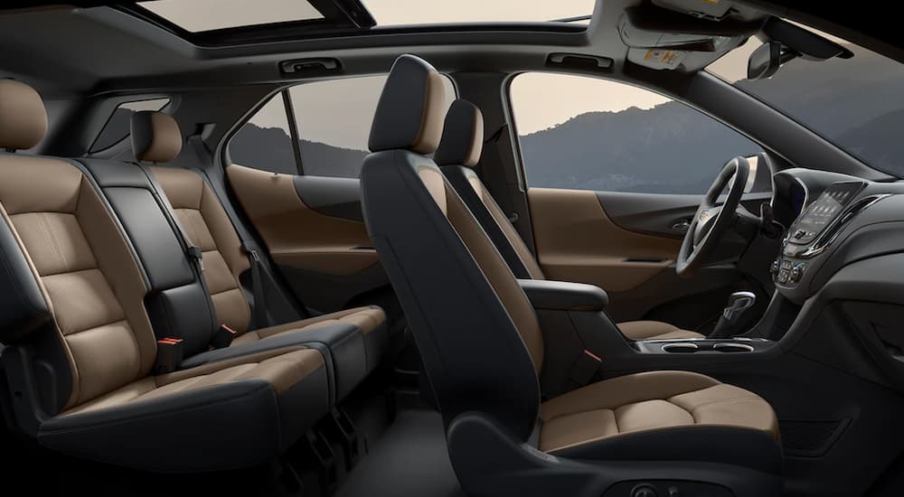 The black and tan interior of a 2022 Chevy Equinox shows two rows of seating.