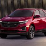 A red 2022 Chevy Equinox RS is shown from the front on a dark background.