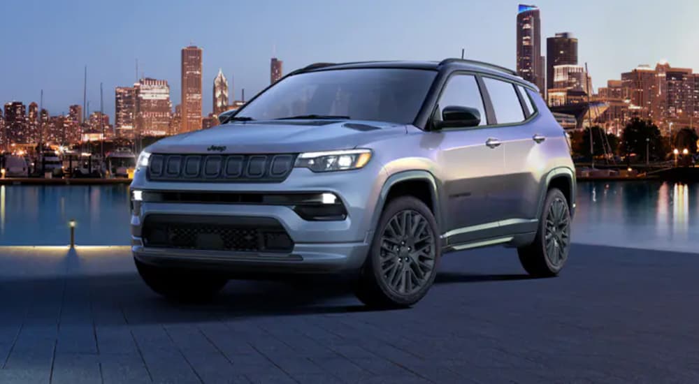 A silver 2022 Jeep Compass is shown from the front parked in front of a river.