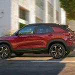 A red 2022 Chevy Trailblazer RS is shown from the side driving through a city.