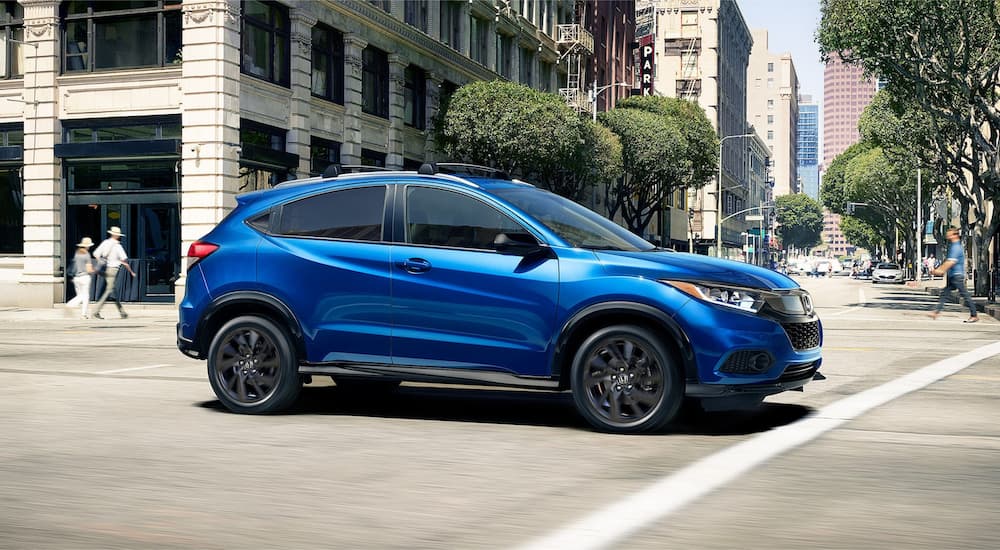 A blue 2022 Honda HR-V is shown from the side on a city street.