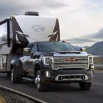 A black 2022 GMC Sierra 3500HD is shown towing a camper.