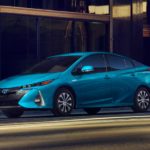 A blue 2022 Toyota Prius Prime Limited is shown at a charging station.