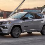 A grey 2022 Jeep Compass is shown driving on a bridge.