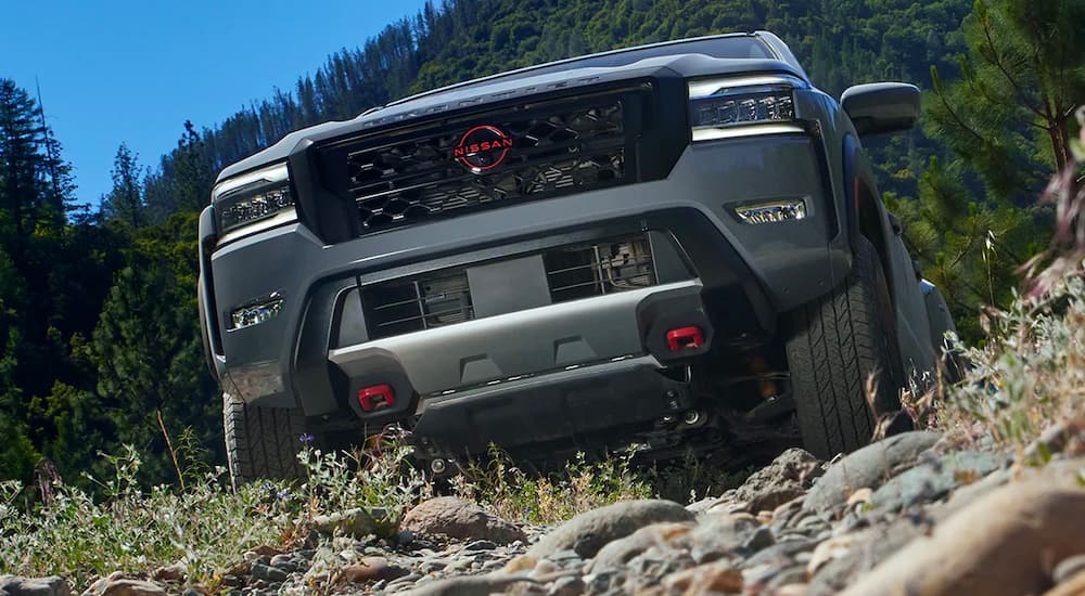 A close up of a 2022 Nissan Frontier PRO-4X off-roading shows the front grille and lights.
