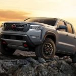A 2022 Nissan Frontier PRO-4X is shown parked on mountain rocks.