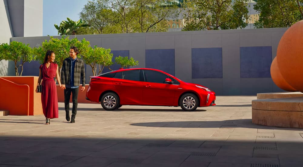 A couple is shown walking away from a 2022 Toyota Prius Limited.