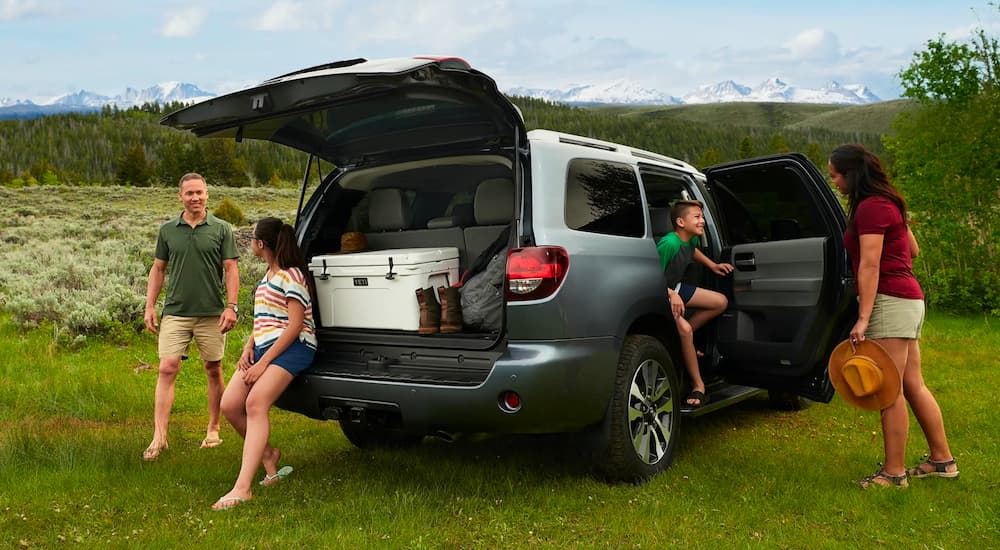A family is shown preparing for a hike outside of their silver 2022 Toyota Sequoia.