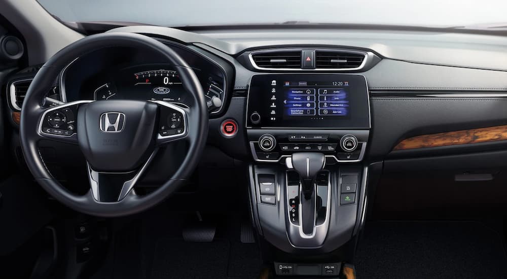 The black dashboard of a 2020 Honda CR-V is shown with wood accents.