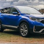A blue 2021 CR-V Elite is shown parked by the side of a lake.