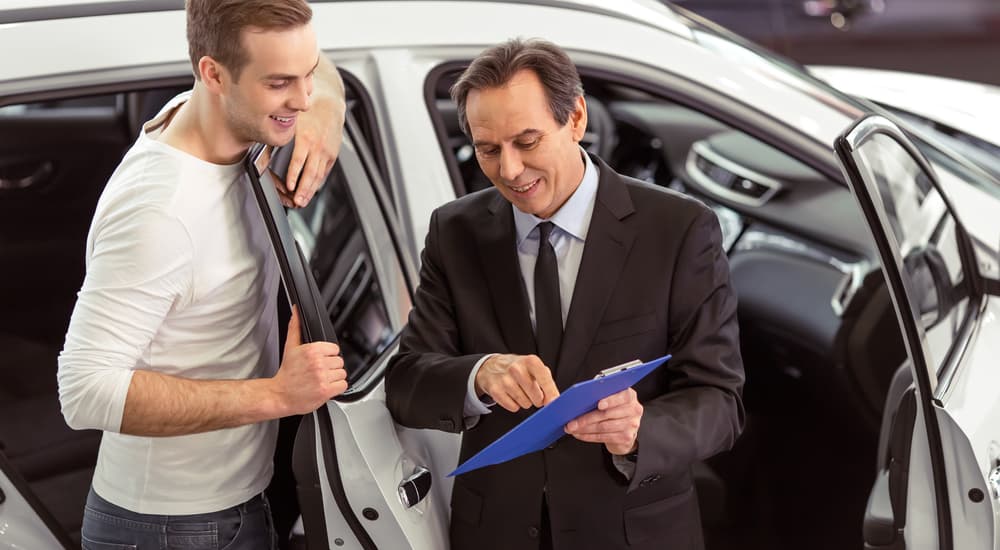 A Certified Pre-Owned Chevy salesman is shown discussing vehicles with a potential buyer.