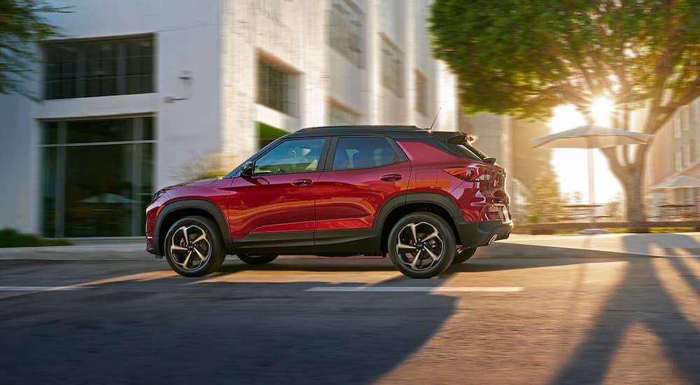 A red 2022 Chevy Trailblazer RS is driving on a city street after visiting a Chevy Trailblazer dealership.