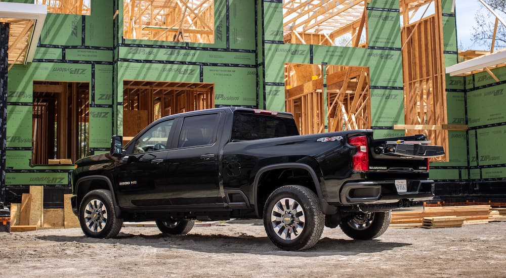 A black 2021 Chevy Silverado 1500 is shown from the side parked at a construction site.