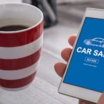 A close up shows someone car shopping on a smart phone.