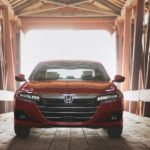 A red 2021 Honda Accord Touring 2.0T is shown form the front parked inside of a covered bridge after leaving a Honda Accord Dealership.