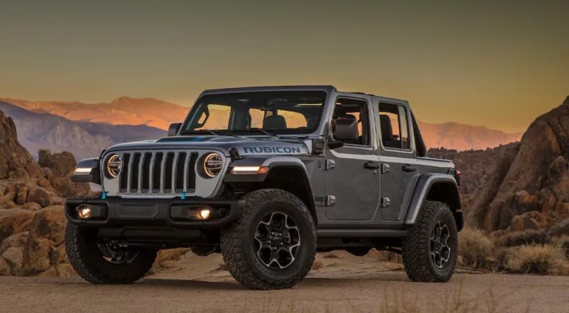 A grey 2021 Jeep Wrangler 4xe is shown from the side parked in a desert after leaving a Jeep dealership.