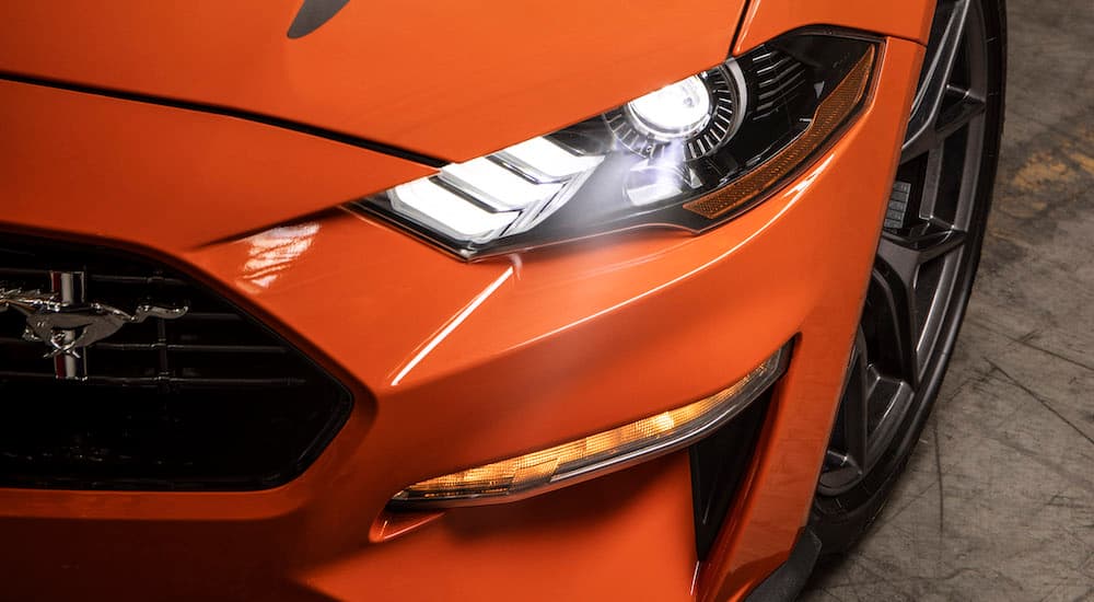 A close up shows the LED headlight on an orange 2020 Ford Mustang High Performance.