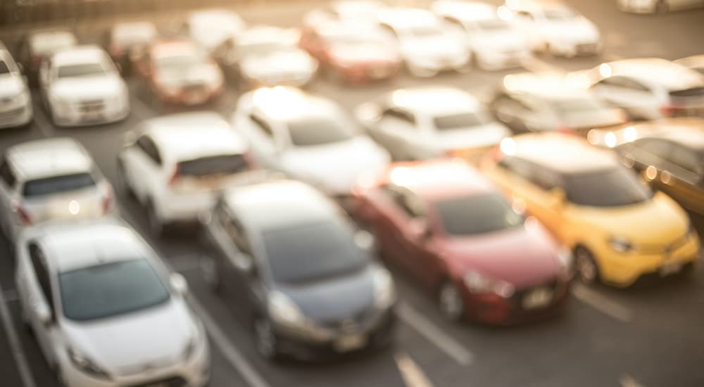 A blurry image shows a lot of used cars.