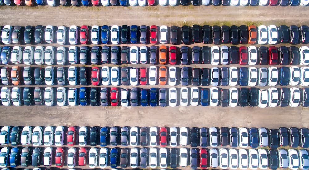 A lot full of used cars are shown from above at at used car dealer.