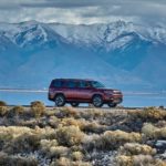 A red 2022 Jeep Wagoneer is shown driving with mountains in the background.