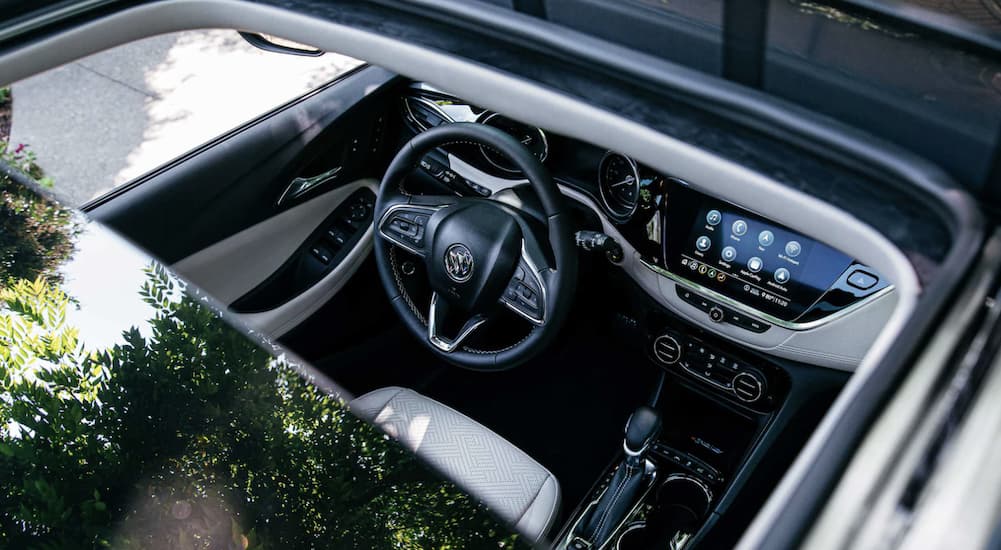 The interior of a 2022 Buick Encore GX shows the steering wheel and infotainment screen through the moonroof.
