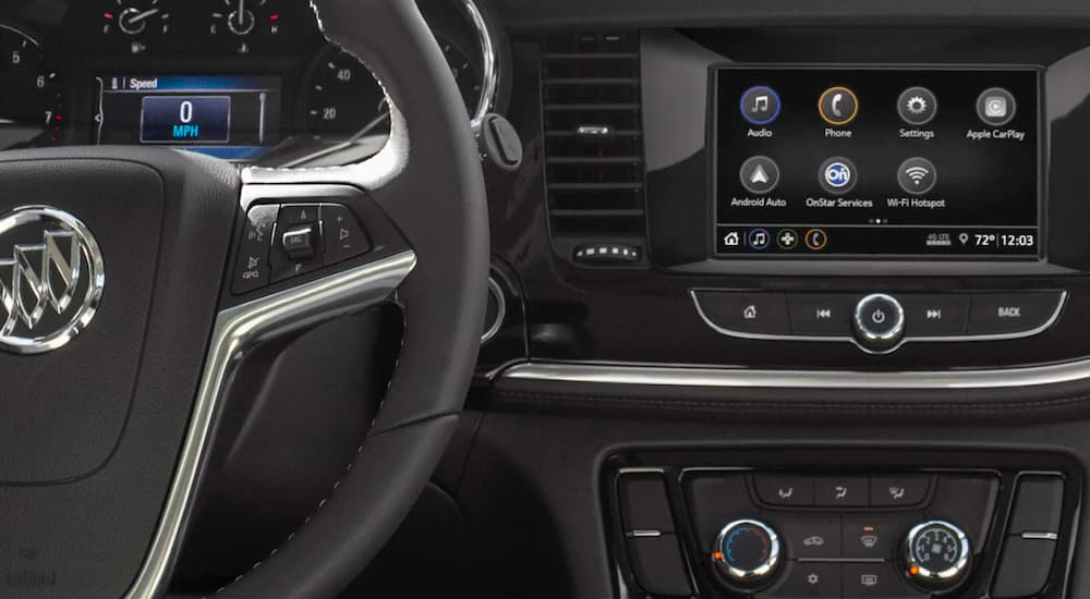 A close up of the steering and infotainment screen are shown in a 2022 Buick Encore.
