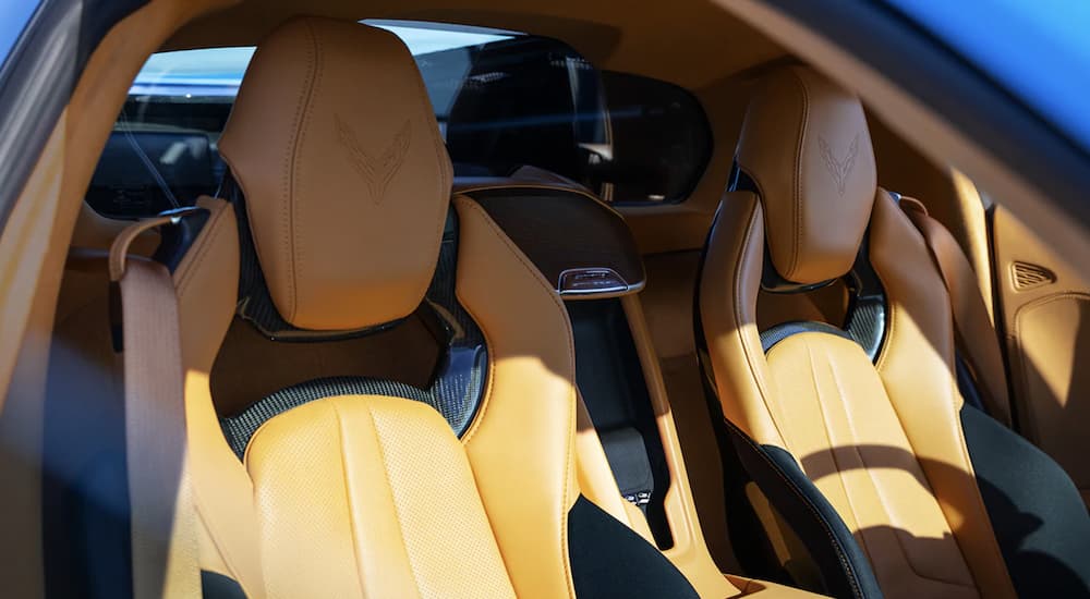 The yellow interior of a 2022 Chevy Corvette shows two leather seats.