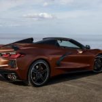 A bronze 2022 Chevy Corvette is shown from the side parked in front of an ocean.