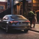 A couple is shown walking next to a grey 2022 Honda Civic.